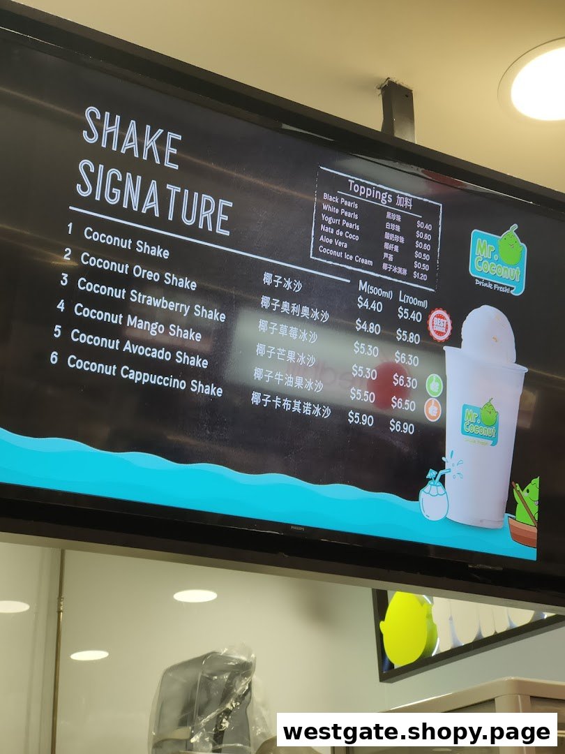 A digital menu board displaying signature coconut shakes and toppings with prices at Mr. Coconut.