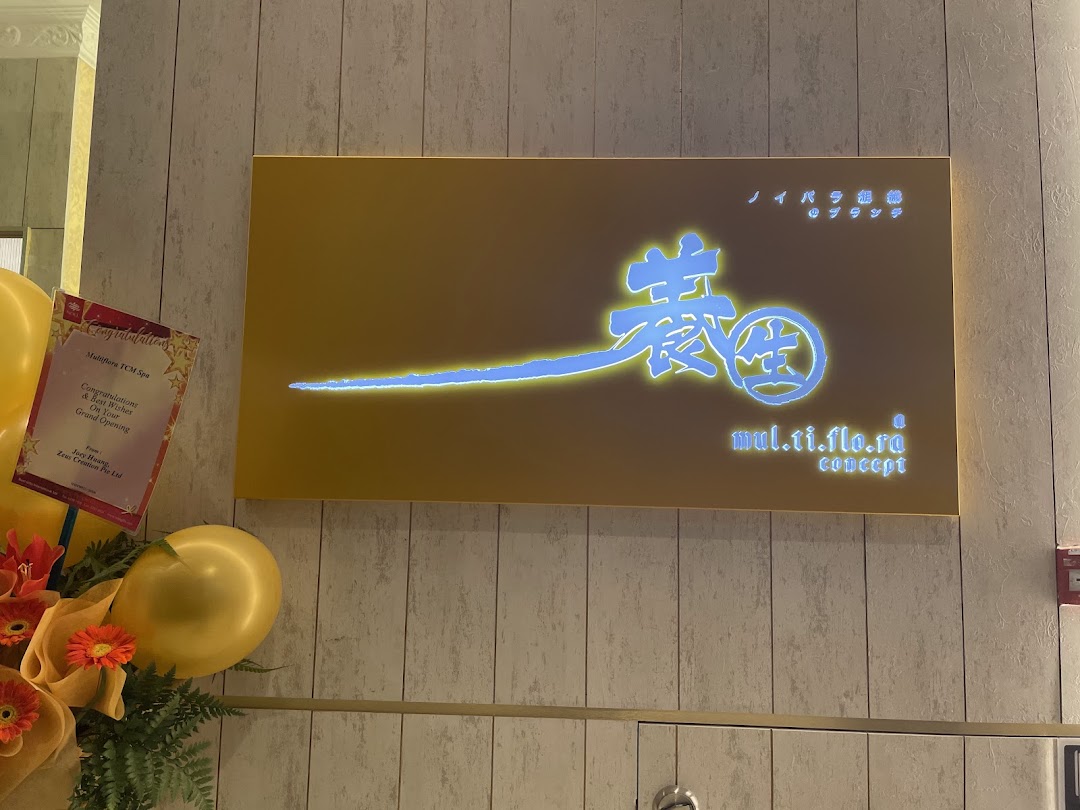 Illuminated Multiflora TCM Spa sign with grand opening decorations.