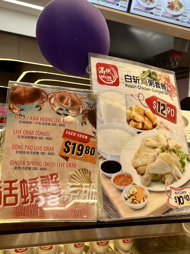 Close-up of promotional displays featuring live crab dishes and a poached chicken congee set.