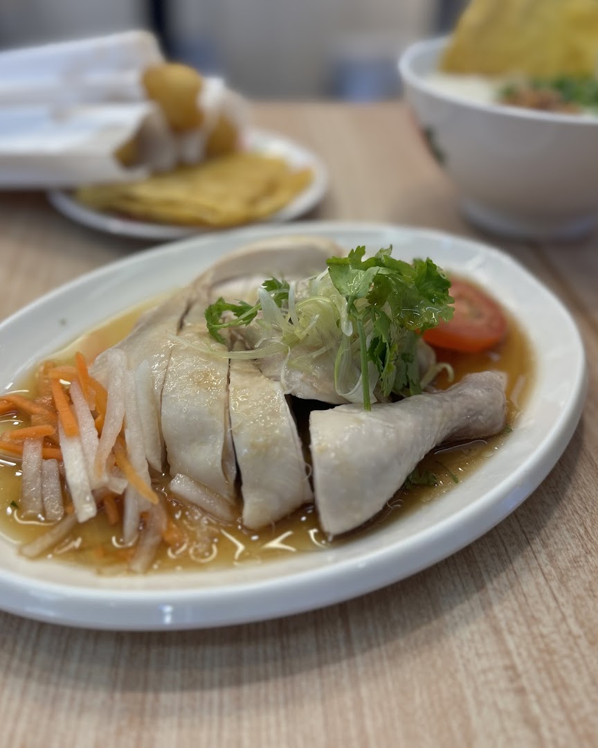 A close-up of a delicious plate of poached chicken with sauce and vegetables.