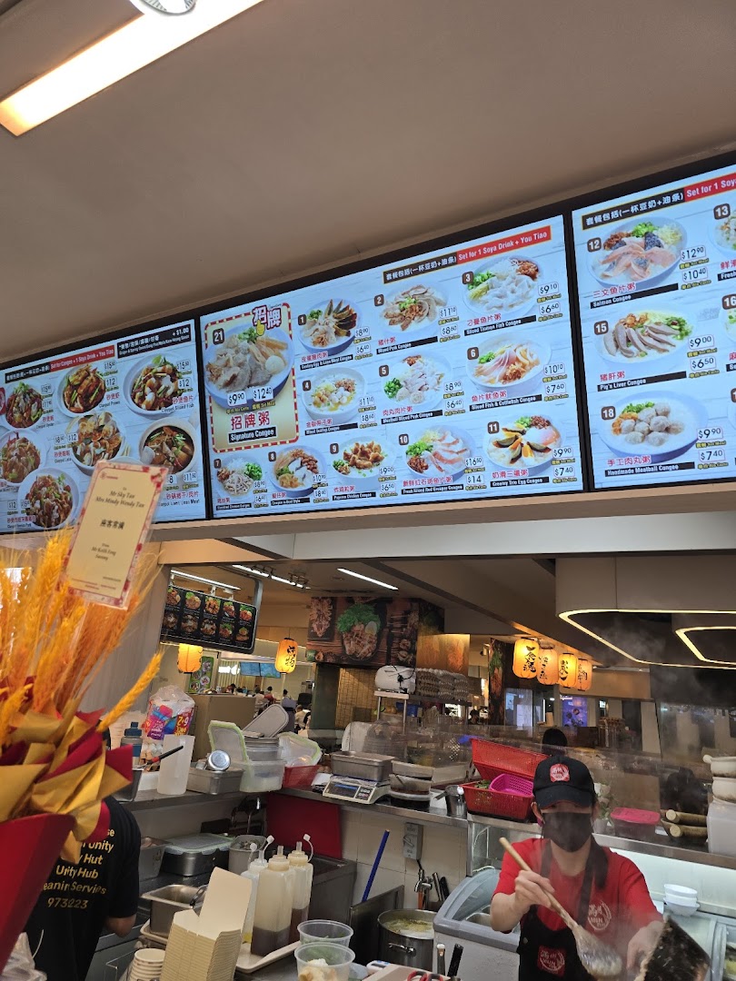 Digital menu boards displaying various congee dishes and prices, with a kitchen area in the foreground.