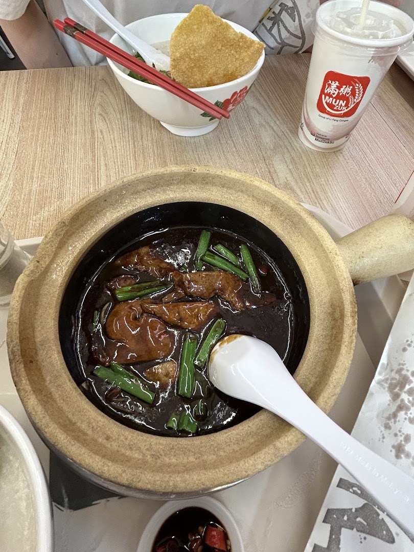 A delicious claypot dish, congee, and a drink served on a table at Mun Zuk.