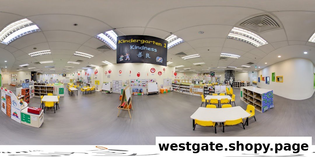 A bright, spacious kindergarten classroom with colorful tables, chairs, and various learning stations.