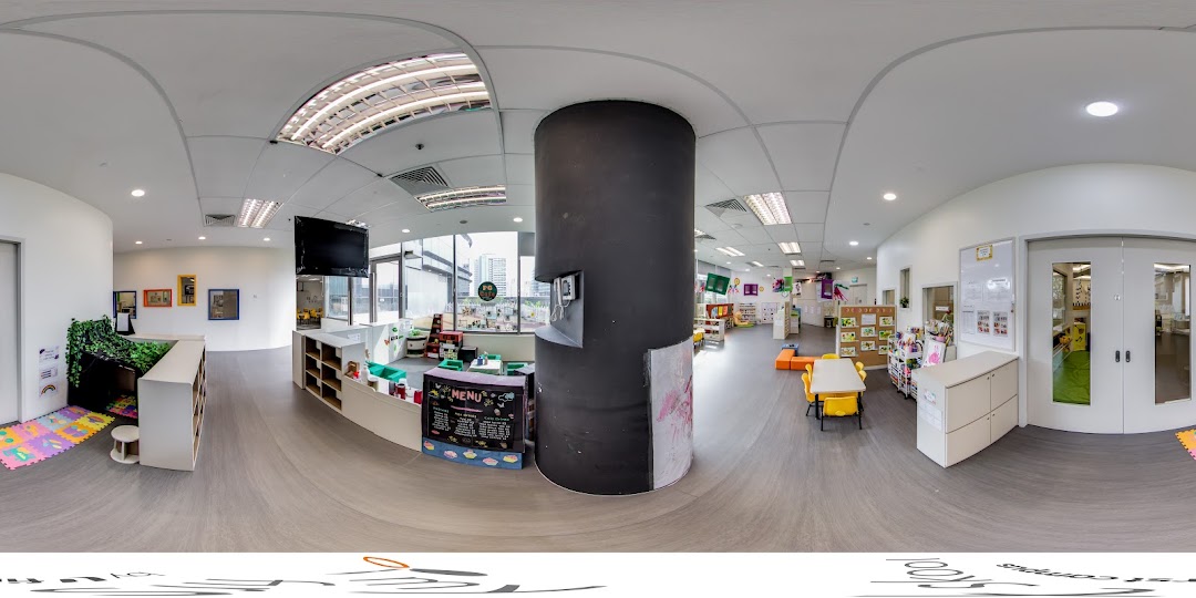 A bright, spacious interior of a childcare center with child-friendly furniture and learning areas.