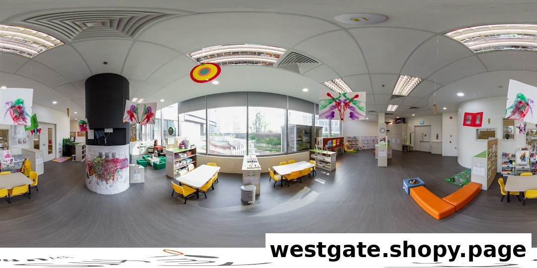 A bright, spacious classroom interior at My First Skool, featuring children's art, tables, and play areas.