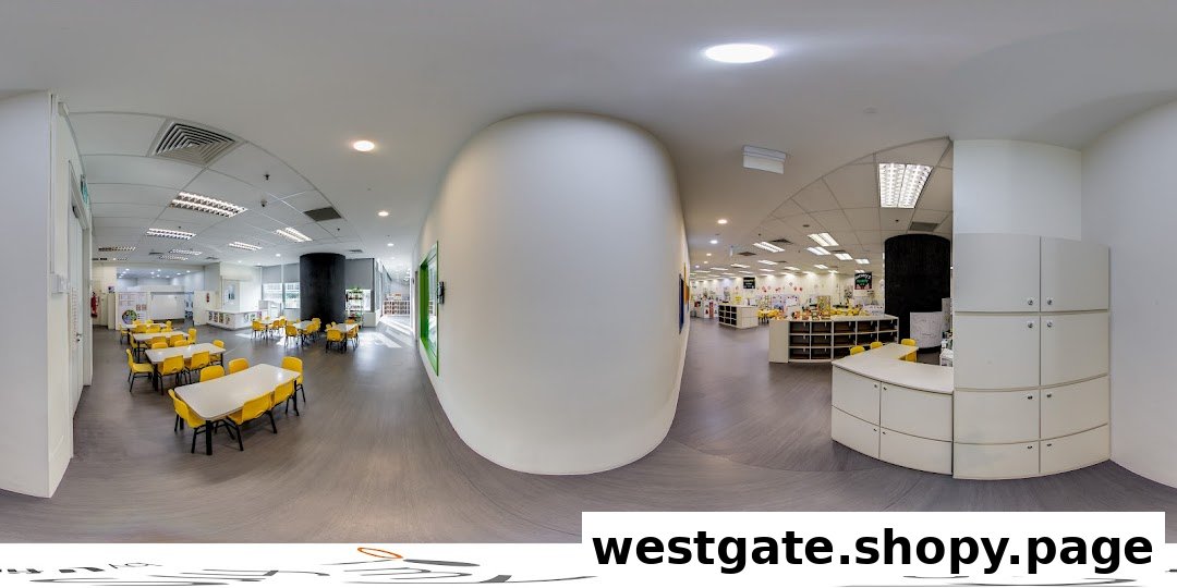A bright, spacious interior of a childcare center with yellow tables and chairs, and activity areas.