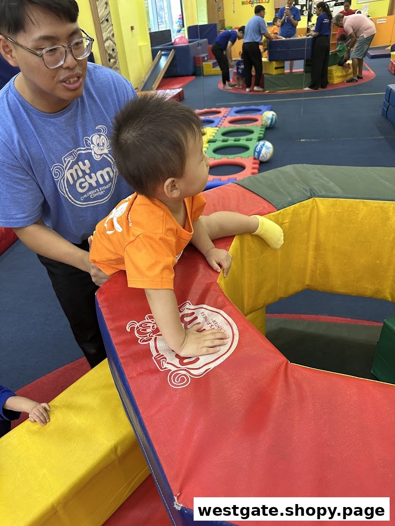 An instructor assists a young child on colorful soft play equipment at My Gym Children's Fitness Center.