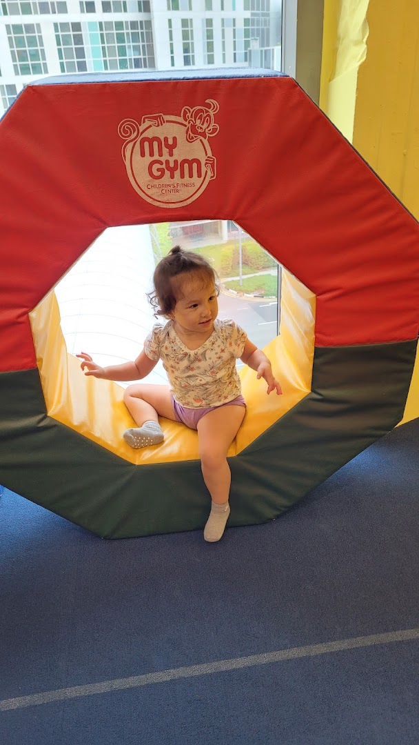 A young child plays inside a colorful soft play structure at My Gym Children's Fitness Center.