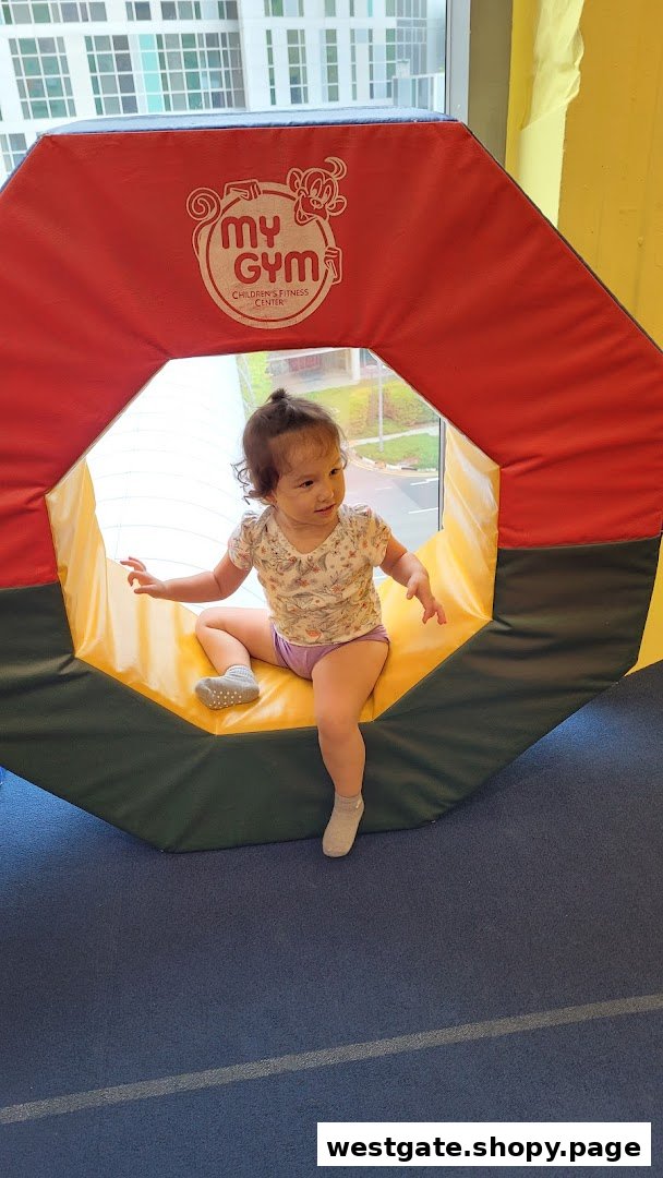 A young child plays inside a colorful soft play structure at My Gym Children's Fitness Center.
