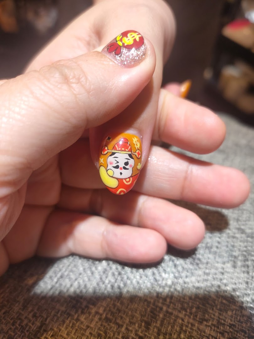 Close-up of a hand showcasing intricate and colorful nail art with a cartoon character design.
