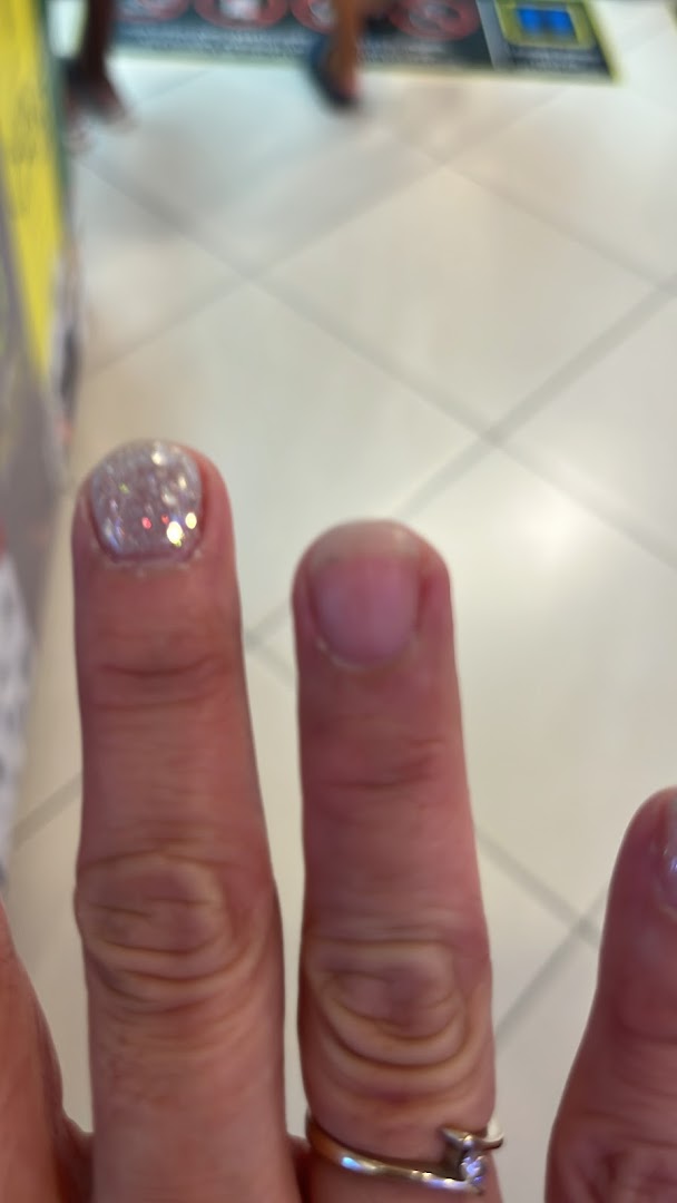 Close-up of a hand showcasing a freshly applied glitter nail polish from Nailz Gallery.