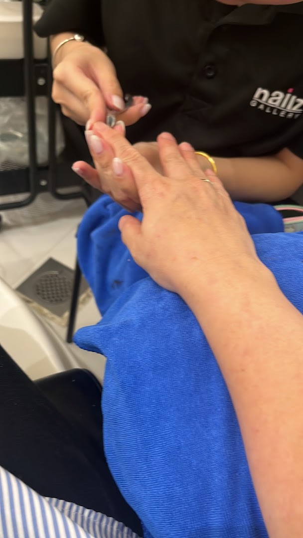 A customer receives a manicure service from a technician at Nailz Gallery.