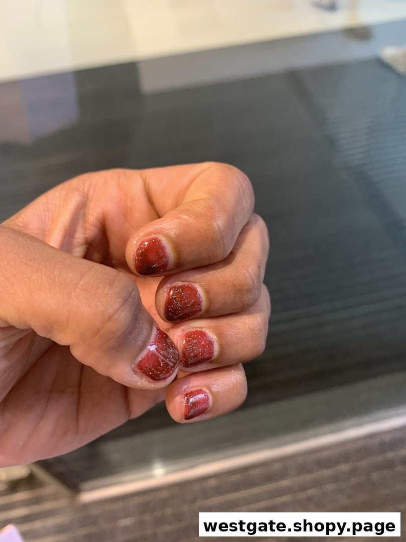 A hand showcasing freshly painted red glitter nails, highlighting a nail salon service.
