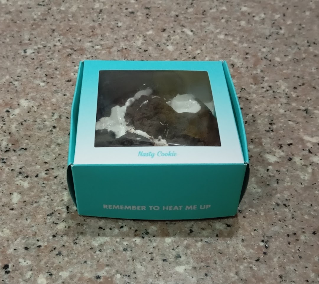 A Nasty Cookie in its signature teal box, with a visible cookie inside.