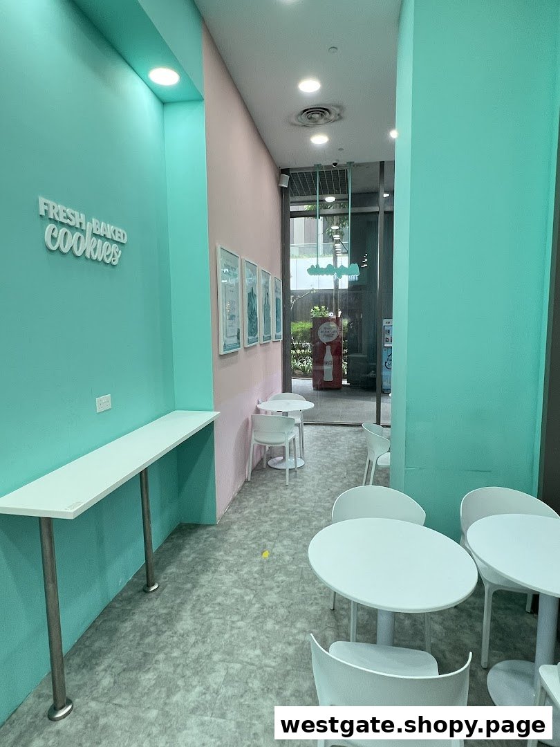 A vibrant interior of Nasty Cookie with mint green and pink walls, featuring seating areas.