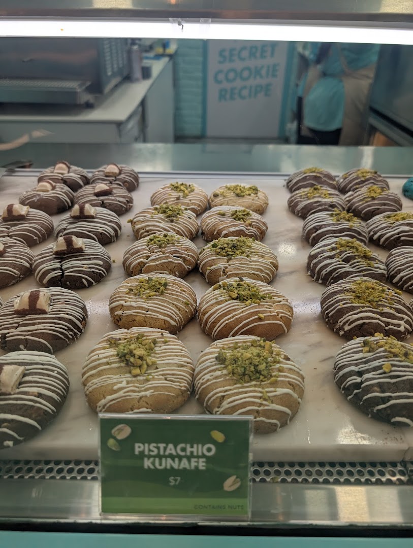 A display case filled with various gourmet cookies, including Pistachio Kunafe, at Nasty Cookie.