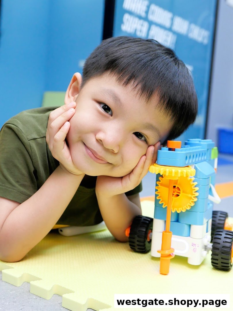 A happy child smiles while engaging with a robotics kit on a soft play mat at NK Robotics.