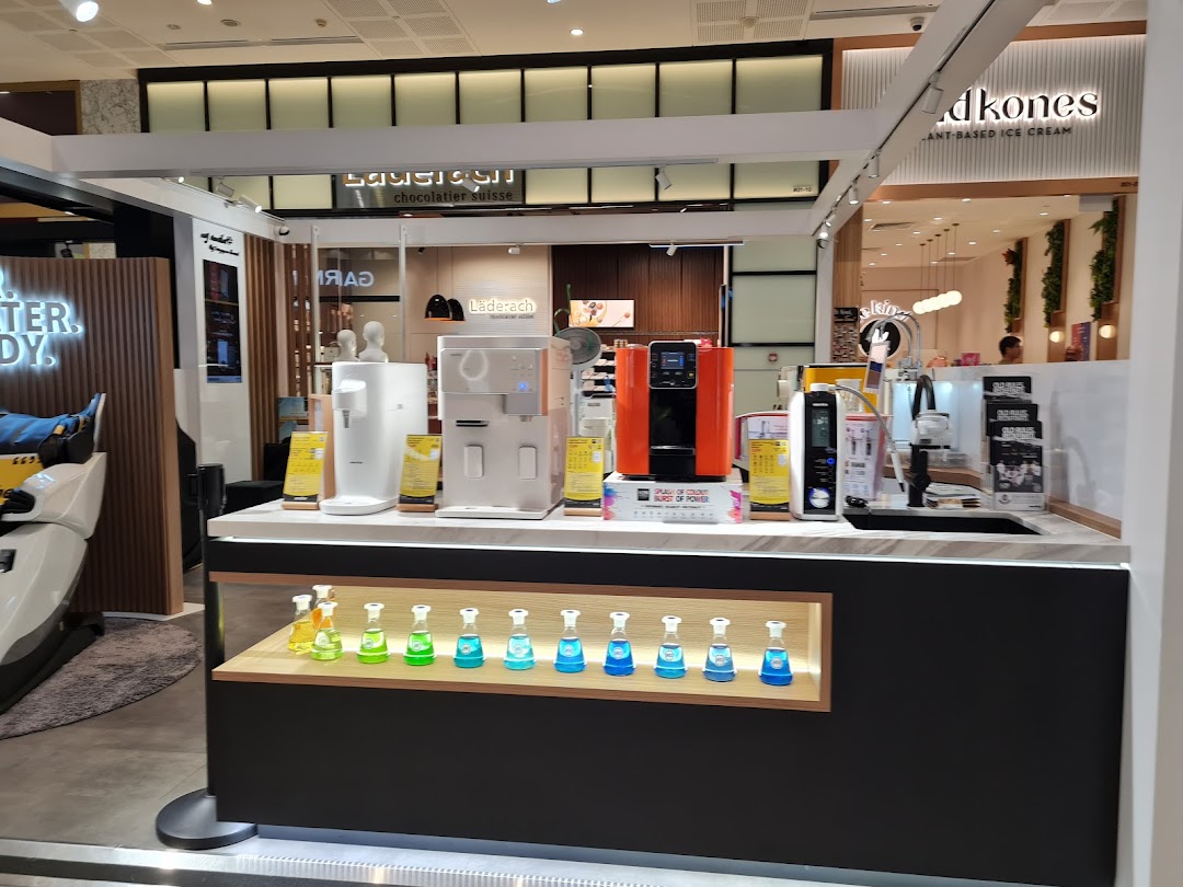 An interior view of Novita Westgate, showcasing various water dispensers, air purifiers, and a massage chair.