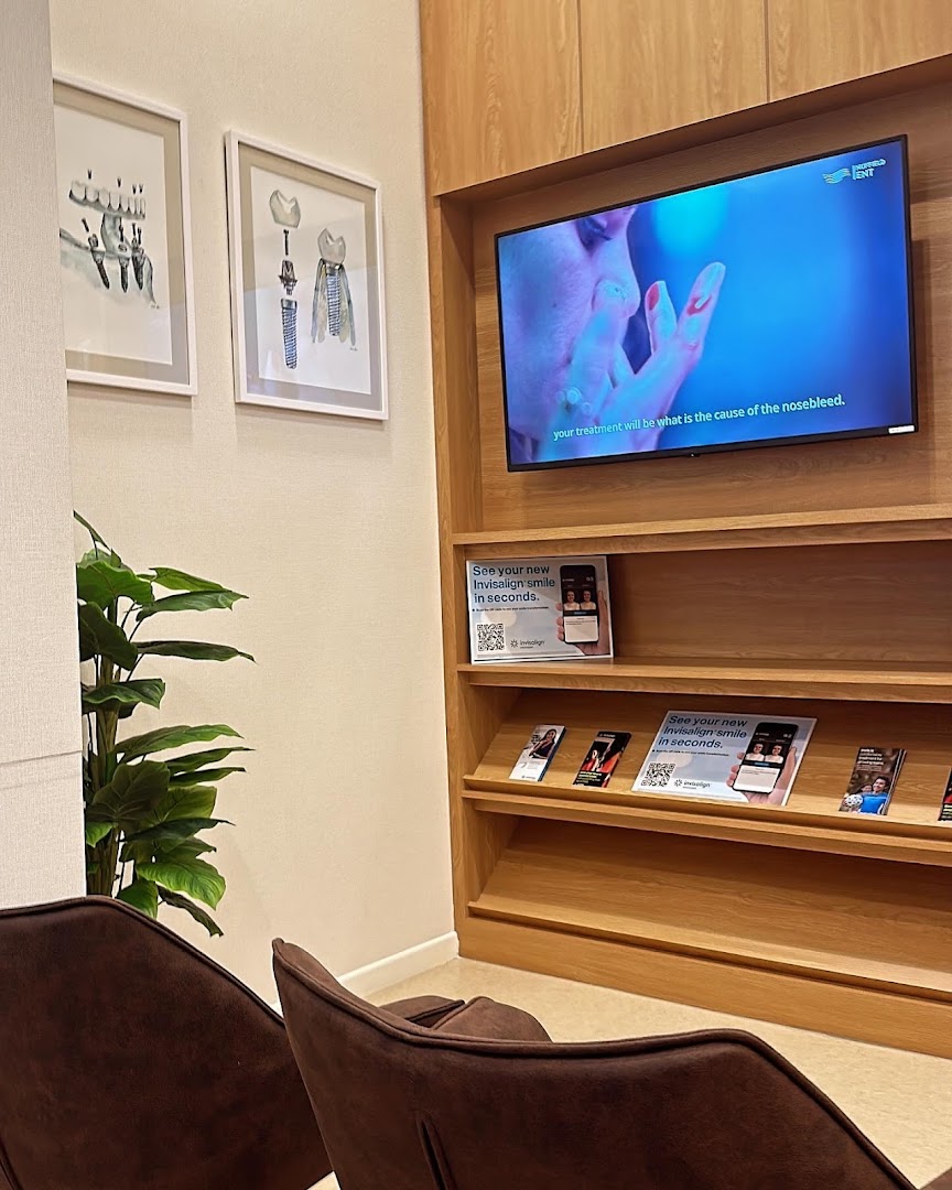 A modern and comfortable waiting area at Nuffield Dental with a TV and informational displays.