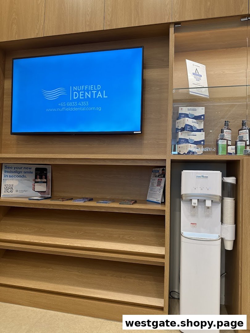 Interior view of Nuffield Dental's waiting area with a branding screen, shelves, and water dispenser.
