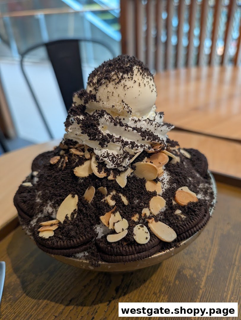 A close-up of a large Korean Bingsu dessert topped with Oreo cookies, whipped cream, ice cream, and almonds.