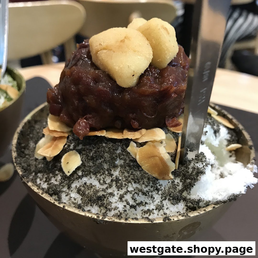 A close-up of a delicious Korean shaved ice dessert with red bean, almond flakes, and black sesame.
