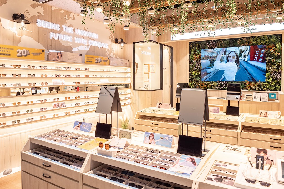 Bright, modern interior of OWNDAYS eyewear store showcasing a wide selection of glasses and sunglasses.