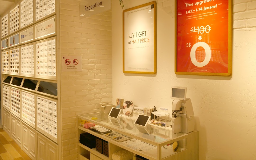 Interior view of OWNDAYS eyewear shop, showcasing glasses displays, reception counter, and promotional offers.