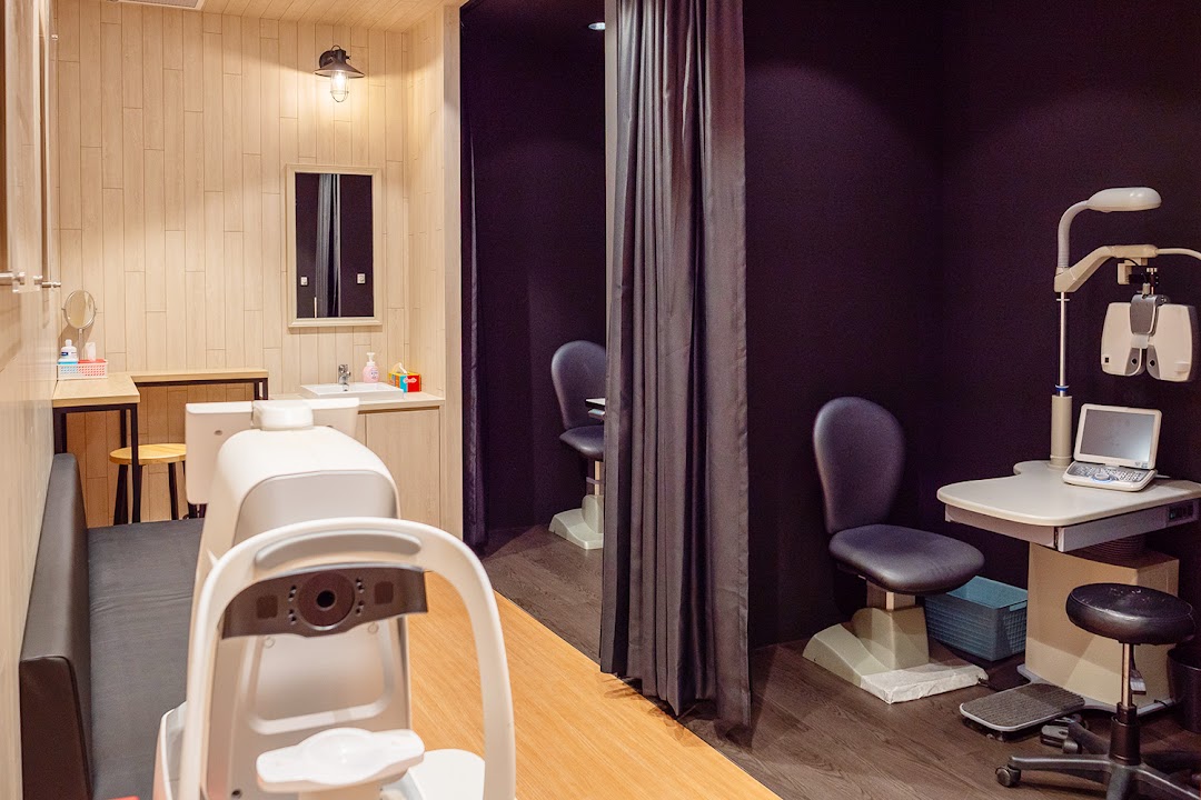 Interior view of an optical shop featuring modern eye examination equipment and a comfortable waiting area.