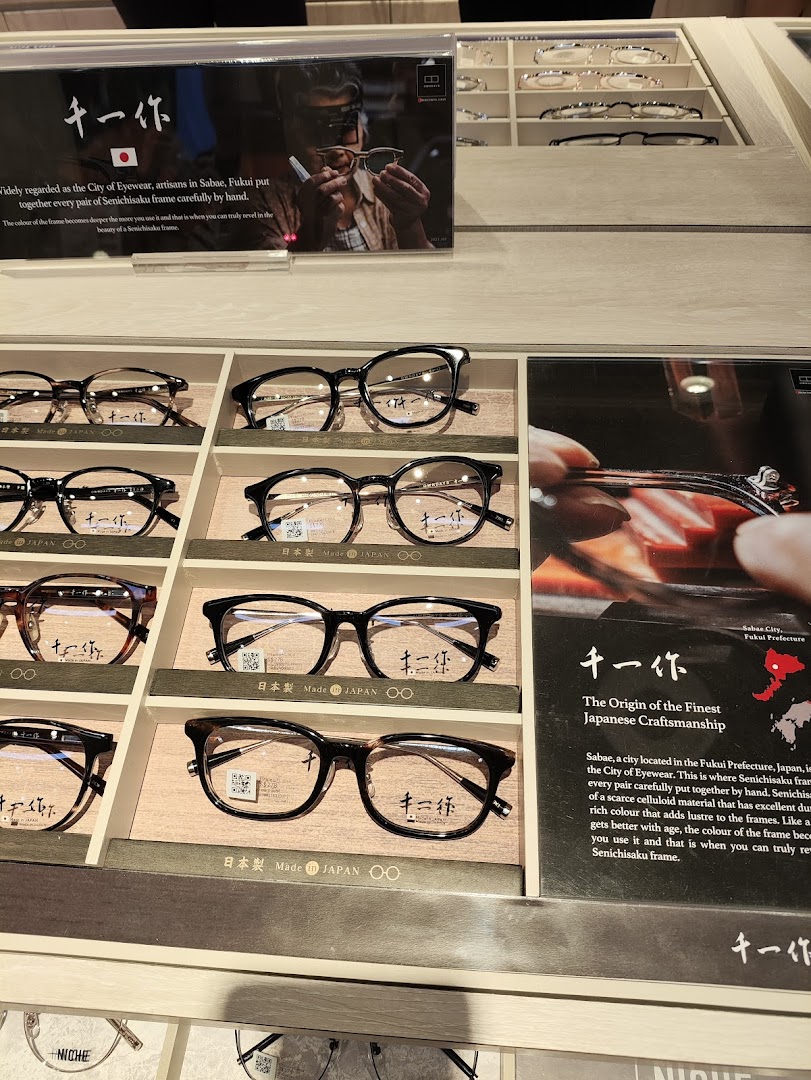 A close-up view of premium eyeglasses displayed in an OWNDAYS store, highlighting Japanese craftsmanship.