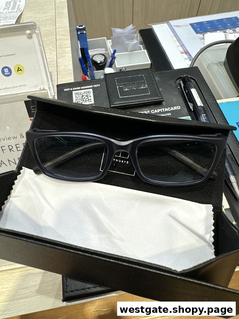 A pair of blue-framed glasses in a case with a cleaning cloth on a counter at OWNDAYS.