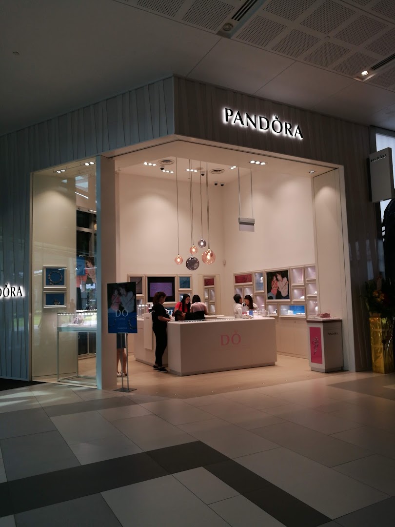The brightly lit entrance of a Pandora jewelry store, showcasing its inviting interior and displays.