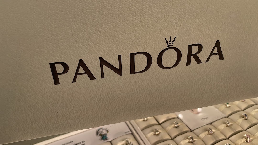Close-up of the Pandora logo above a display case filled with various jewelry pieces.