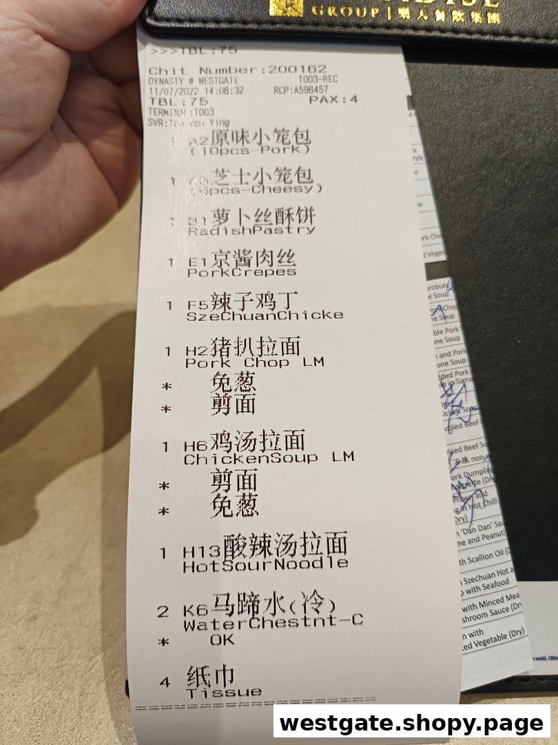 A close-up view of a dining order chit from Paradise Dynasty at Westgate, listing various dishes.