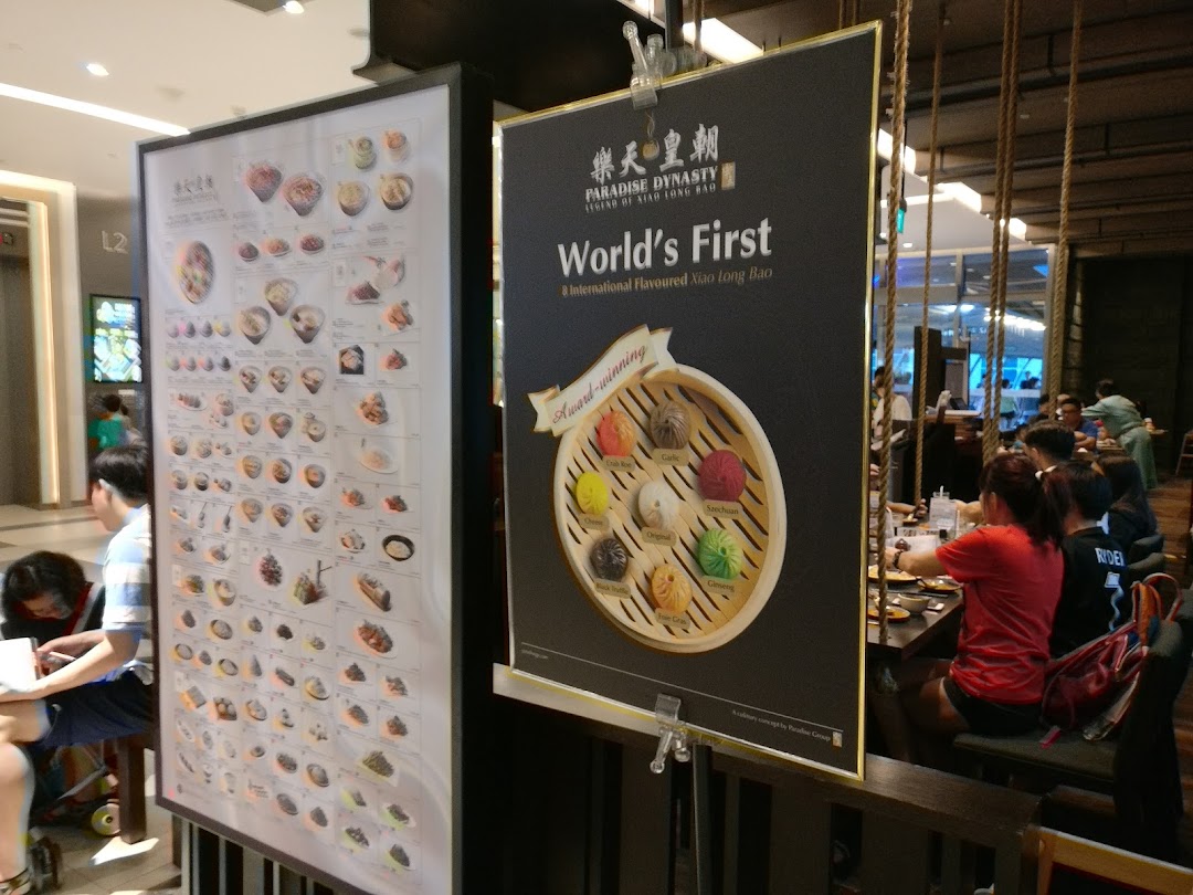 Two large display boards showcasing Paradise Dynasty's unique Xiao Long Bao and other dishes at the shop entrance.