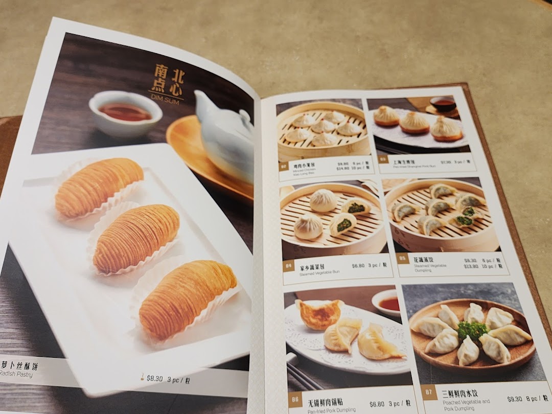 A vibrant menu page showcasing a variety of delicious dim sum dishes with photos and prices.