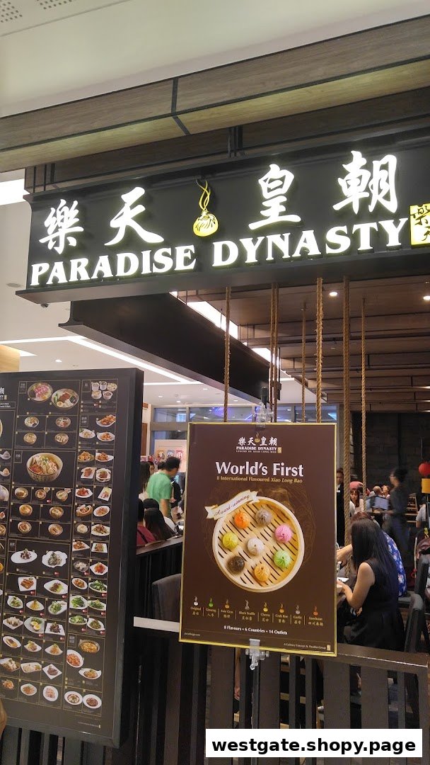 The entrance of Paradise Dynasty restaurant, featuring its prominent signage and promotional displays for its signature Xiao Long Bao.