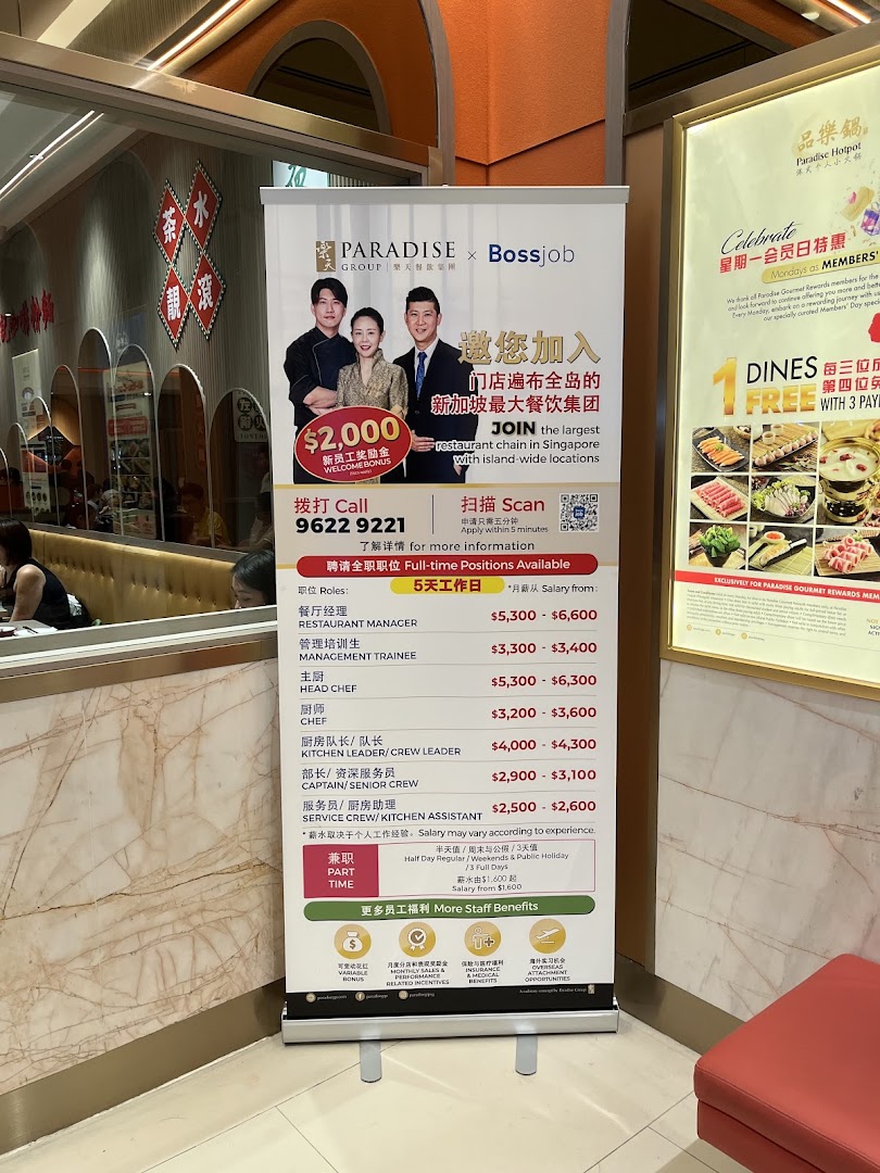 An interior shot of Paradise Hotpot featuring a recruitment banner for Paradise Group and a promotional poster.