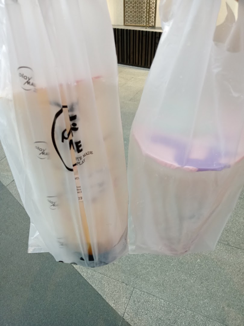 Two PlayMade bubble tea drinks in branded plastic bags, ready for enjoyment.