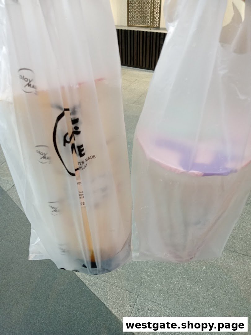 Two PlayMade bubble tea drinks in branded plastic bags, ready for enjoyment.