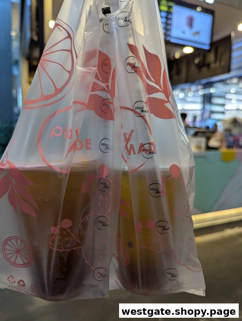 Two PlayMade bubble tea drinks in a branded plastic carrier bag.