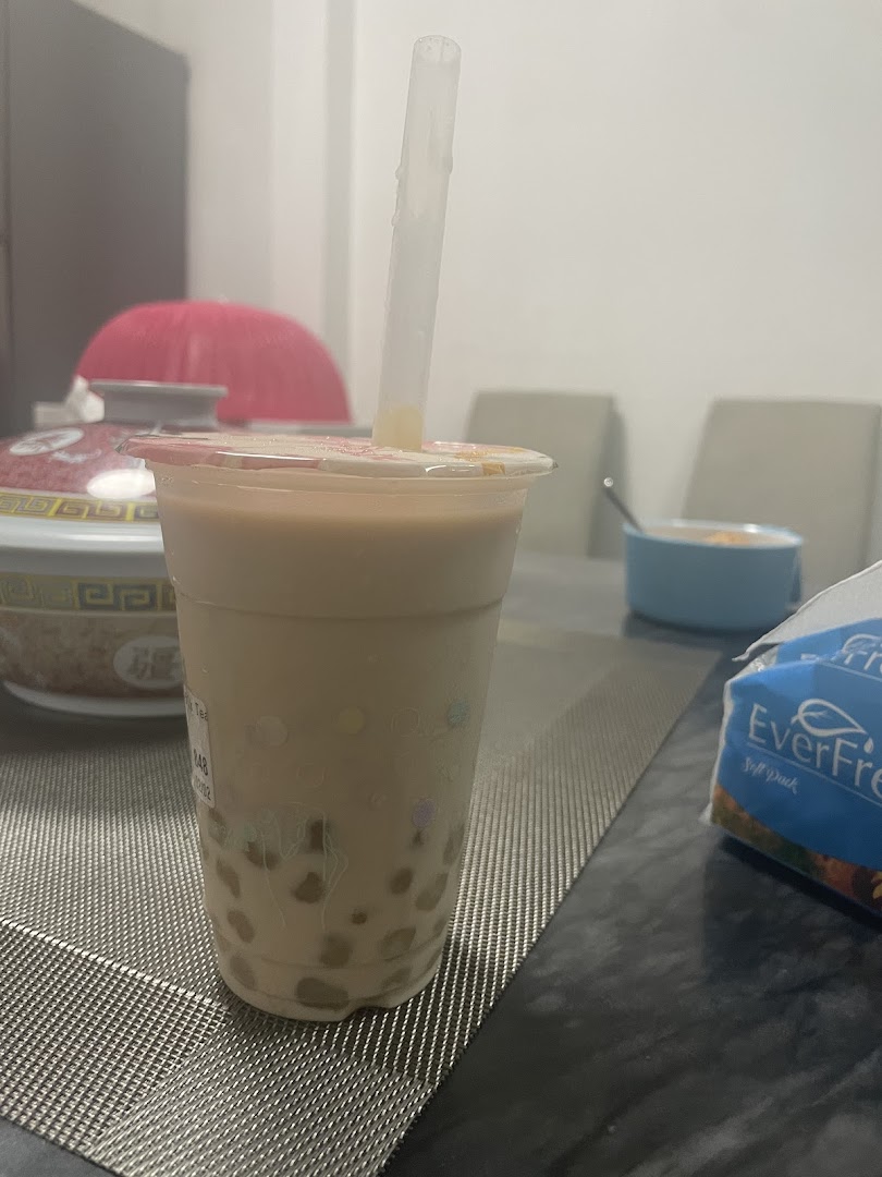 A refreshing bubble tea drink from PlayMade, featuring tapioca pearls and a straw, on a table.