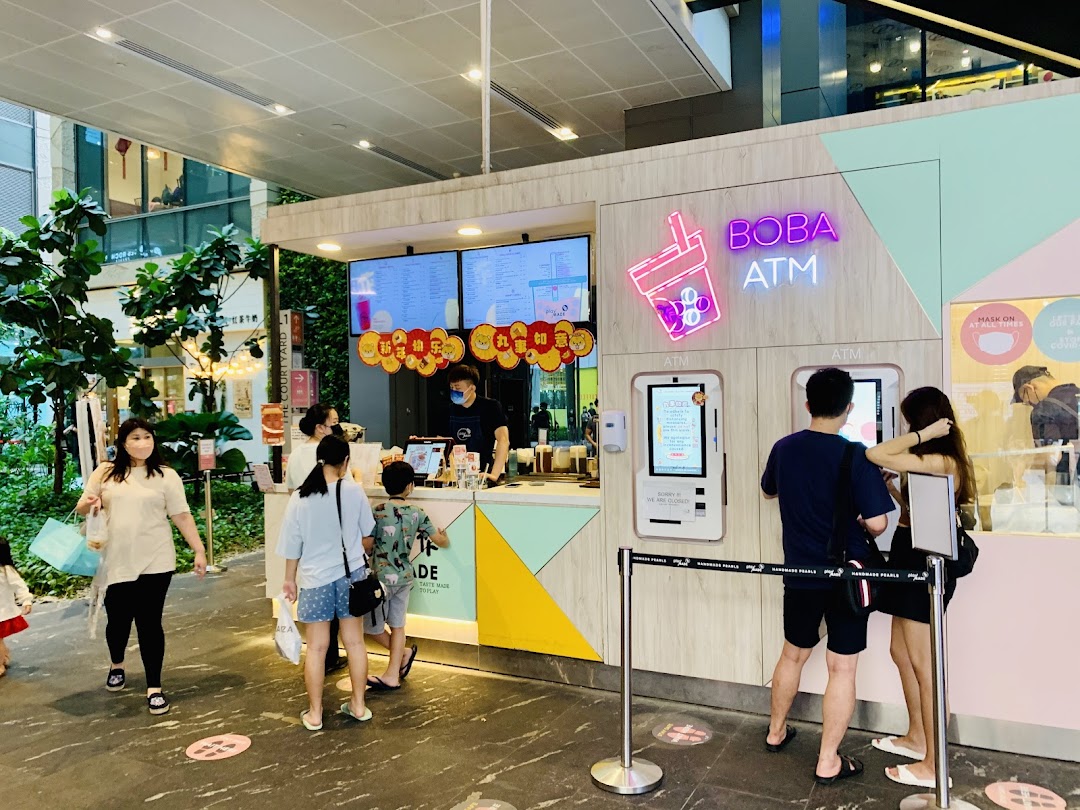 Customers interact with staff and use self-service kiosks at the PlayMade bubble tea shop.