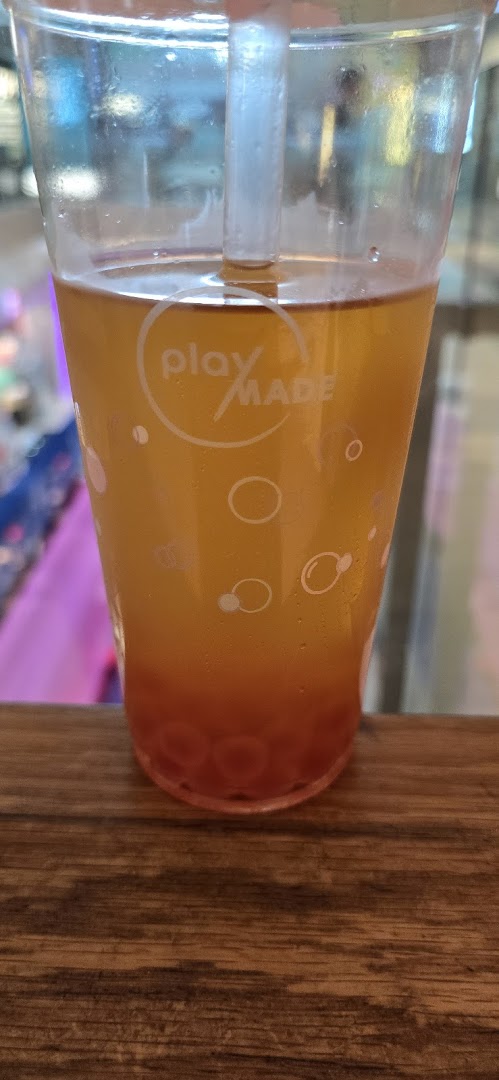 A close-up of a refreshing PlayMade bubble tea with colorful boba pearls.