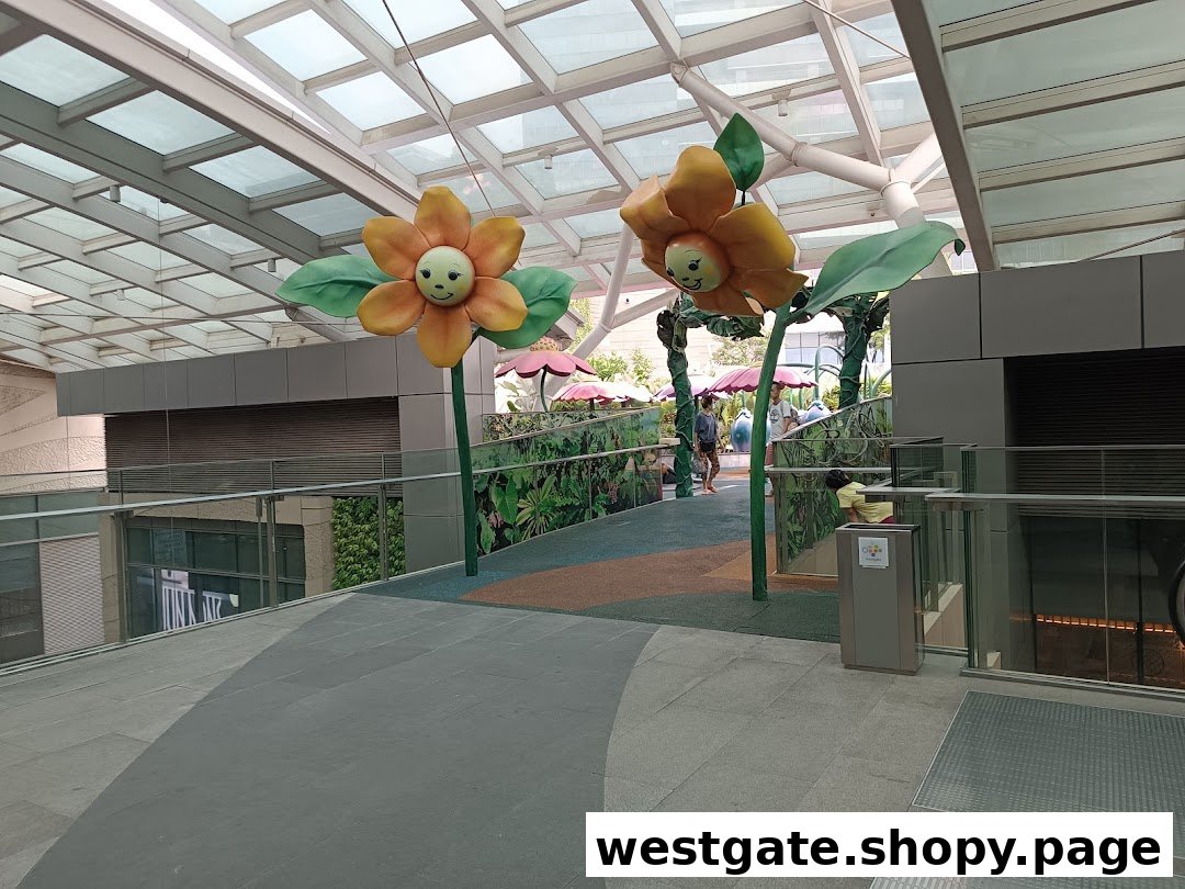A mall walkway featuring large, whimsical flower sculptures and a vibrant play area in the background.
