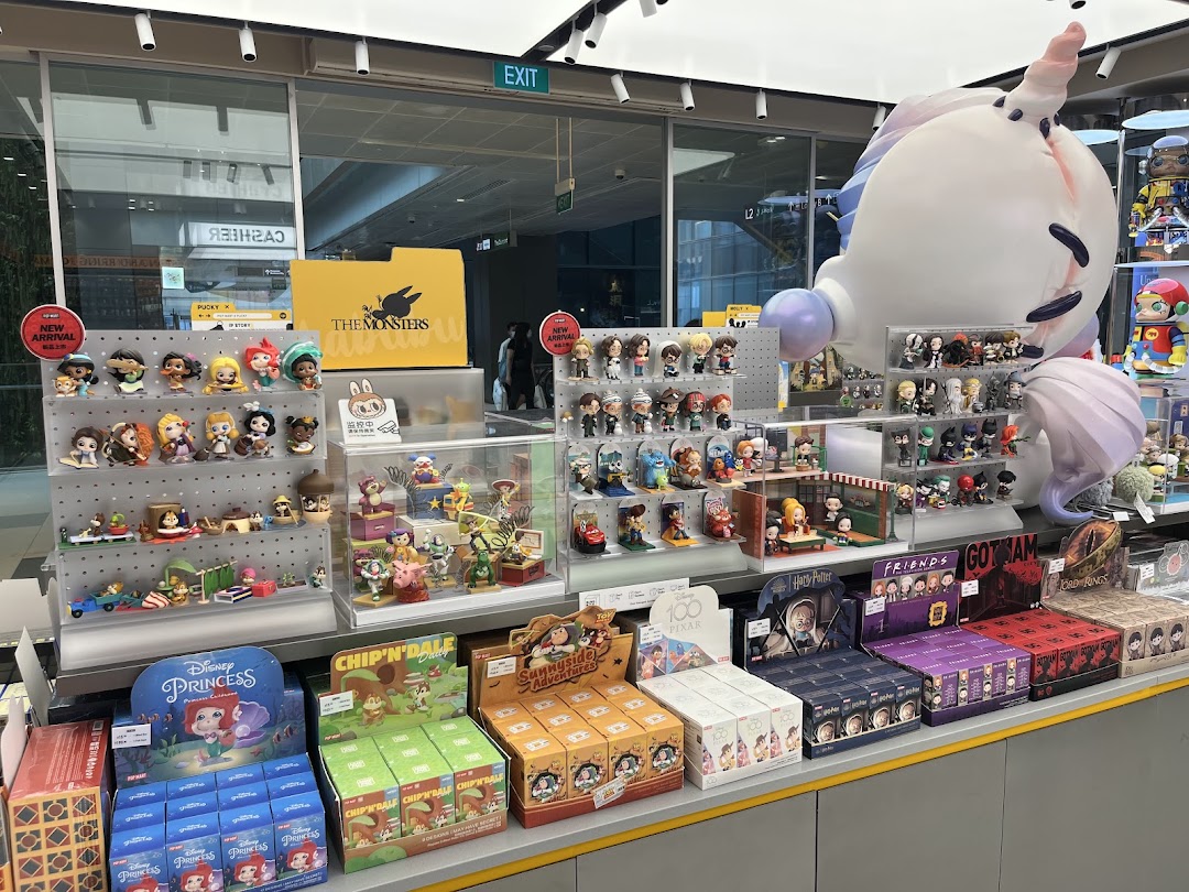 A vibrant display of collectible figures and blind boxes, featuring popular characters and a large unicorn statue.