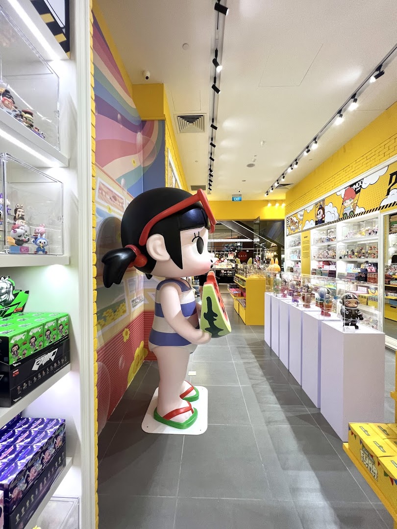 A vibrant POP MART store interior featuring a large character statue and colorful displays of collectible toys.