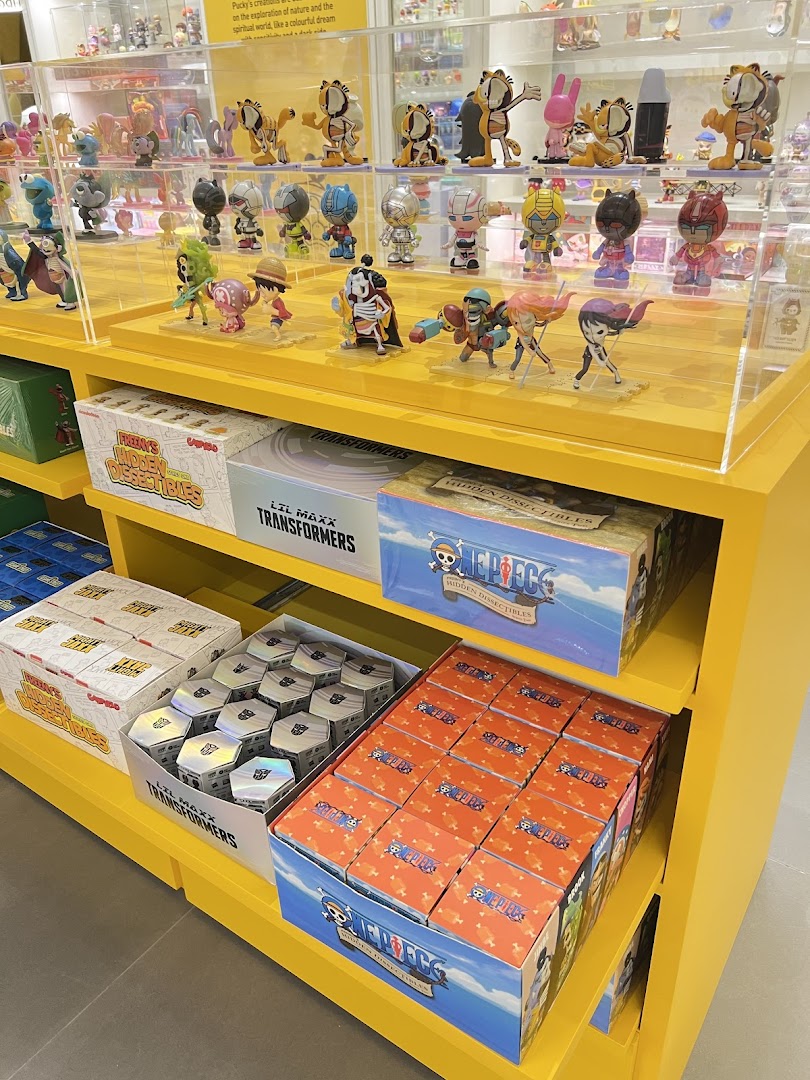Shelves filled with collectible figures and blind boxes, featuring One Piece and Transformers themes.