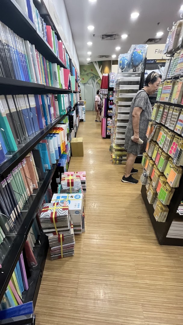 Interior view of POPULAR Bookstore, showing shelves filled with stationery and a customer browsing.
