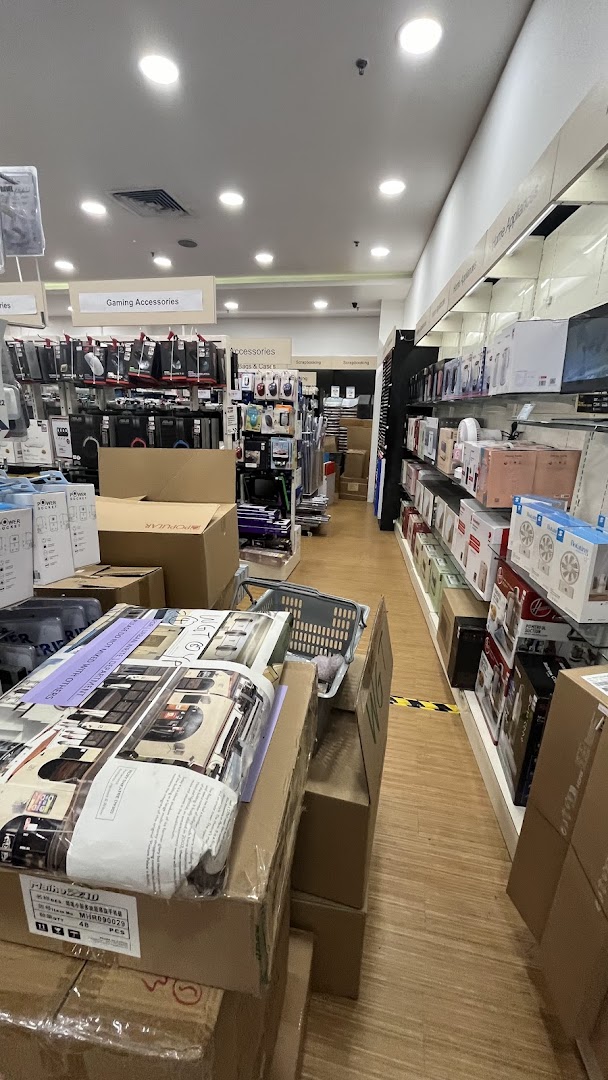 An interior view of a retail store aisle with shelves displaying products and stacked boxes.